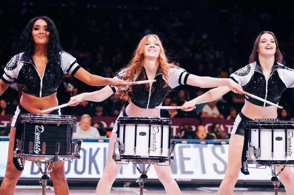 Three-dancer drumline performance on the parquet, snare drums on stands