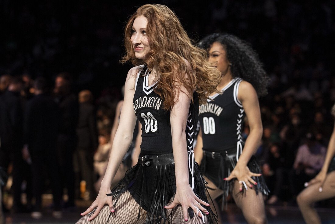 Mid-routine in a fringe-tassel skirt and BROOKLYN 00 jersey top