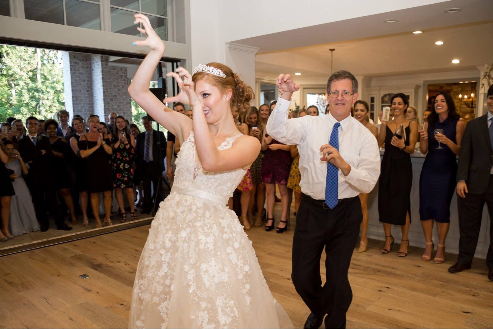 Father-daughter dance at the reception, guests cheering